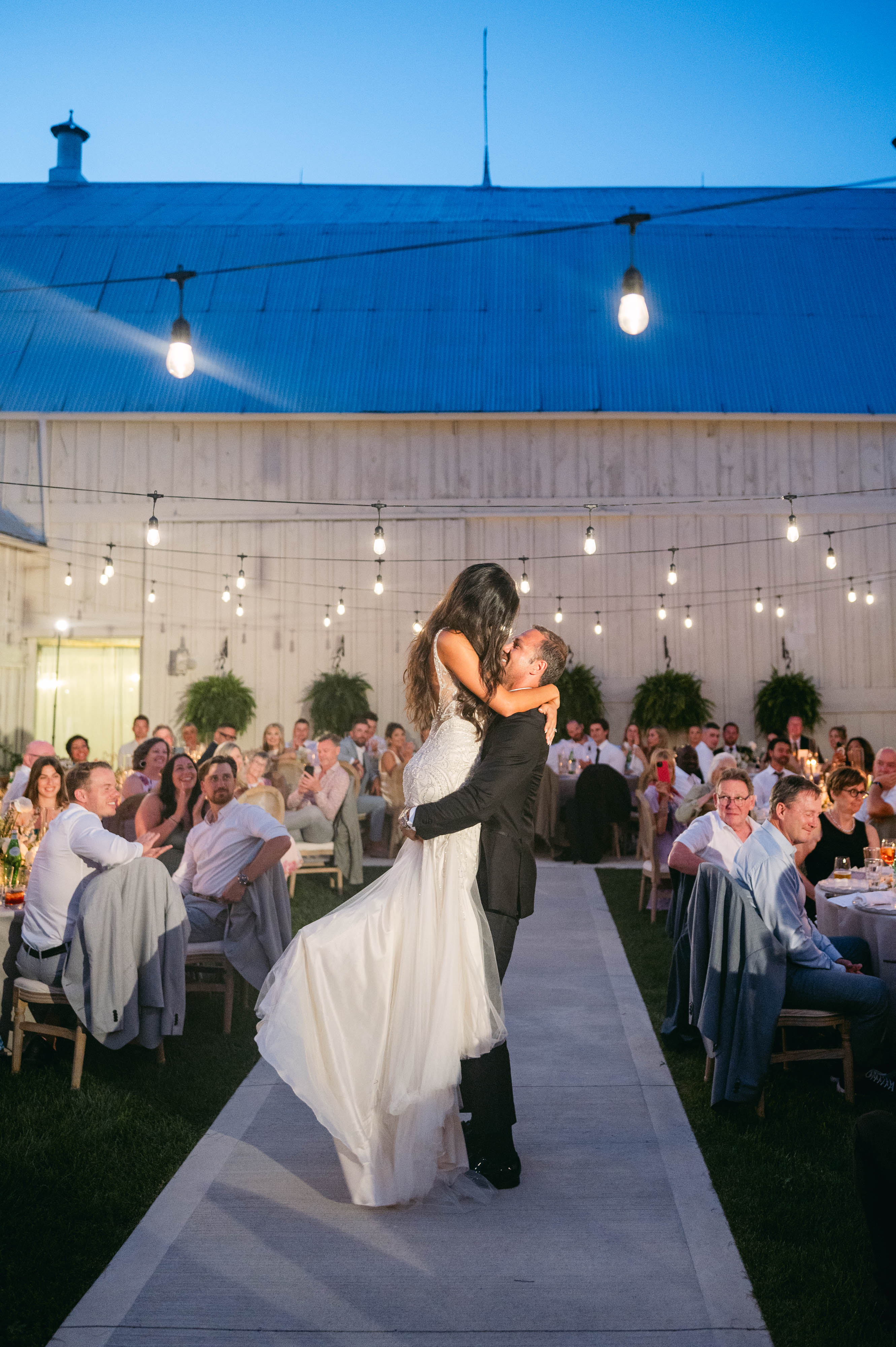 Bride and groom's first dance under string lights in the courtyard reception at Sorella 1881