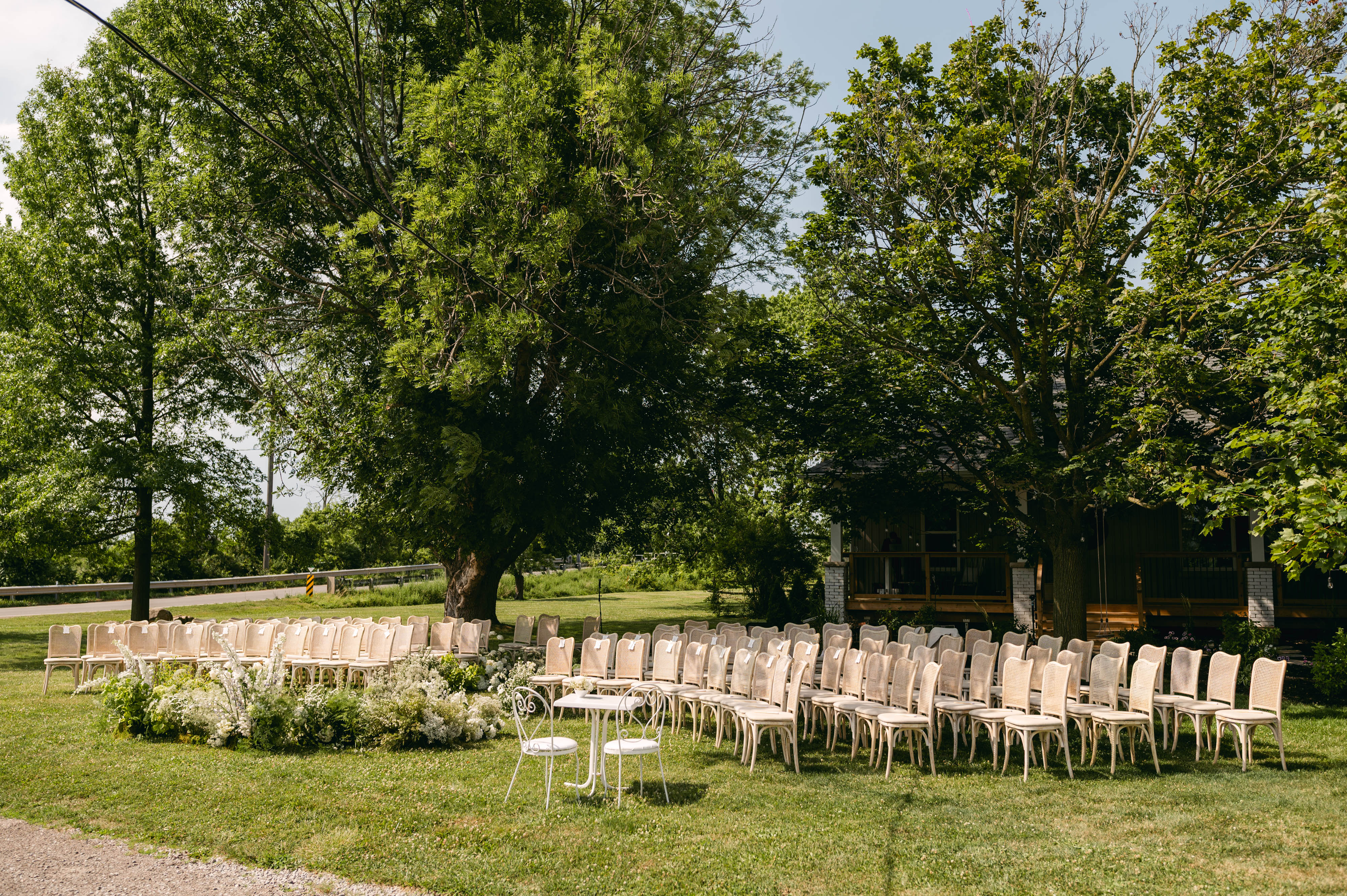 Curved arrangement of ceremony chairs around a floral altar on the Sorella 1881 grounds