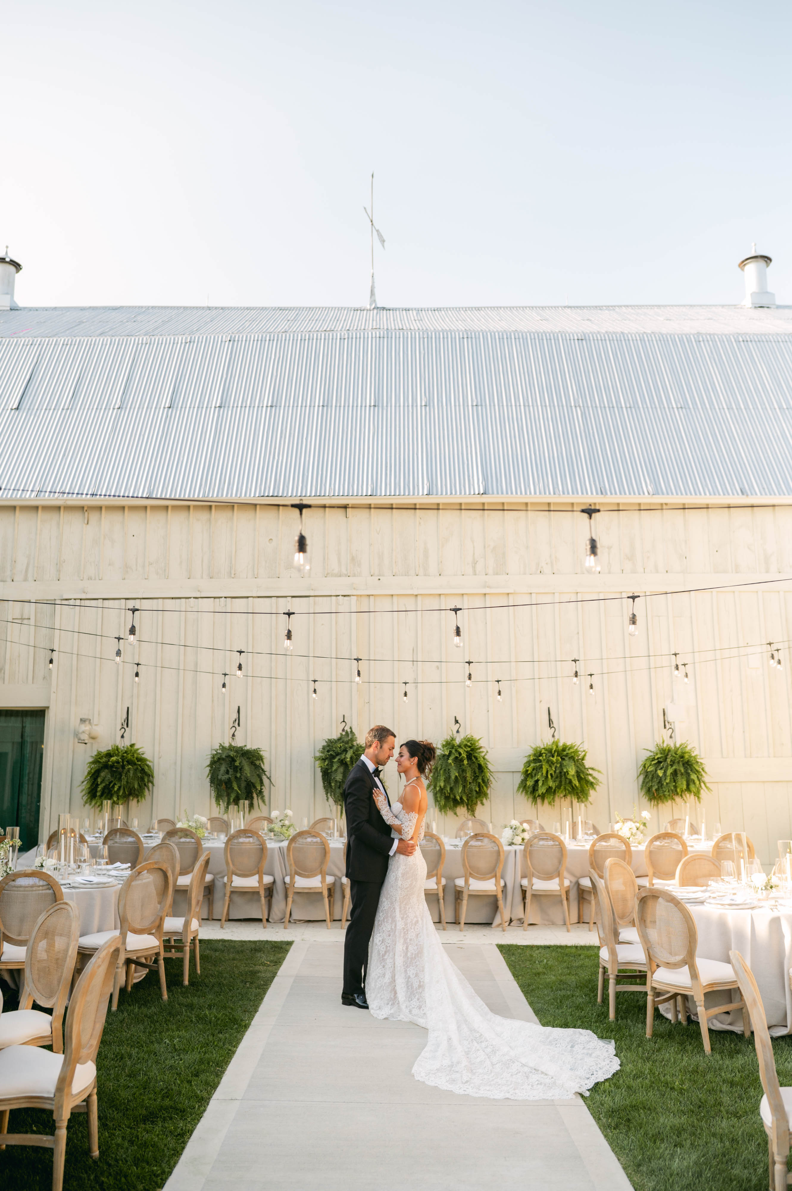 The Courtyard at Sorella 1881 — bride and groom in the courtyard reception with string lights against the barn