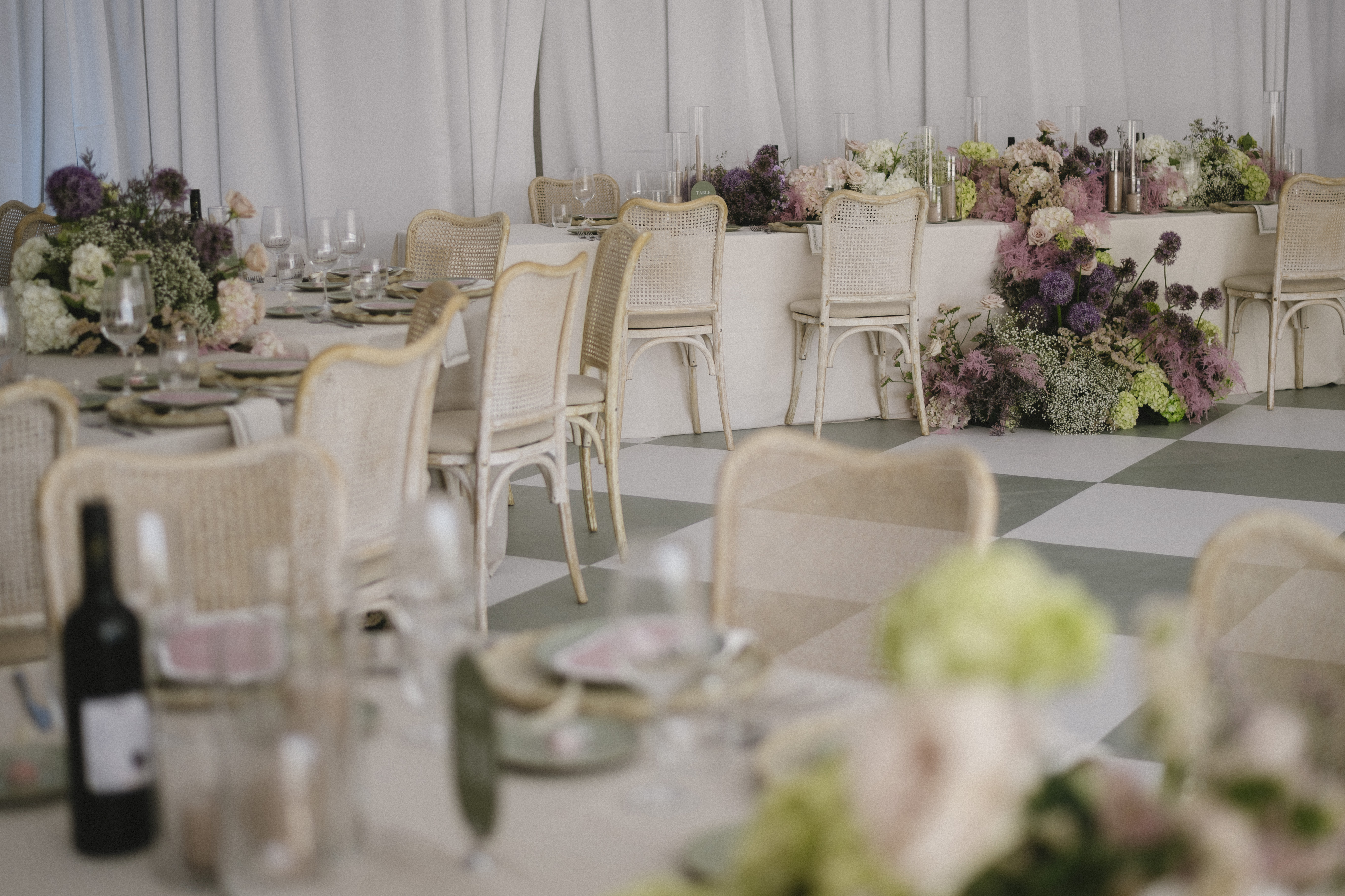 Wide interior view of the Blanc Marquee reception at Sorella 1881 with cane chairs and lavender florals