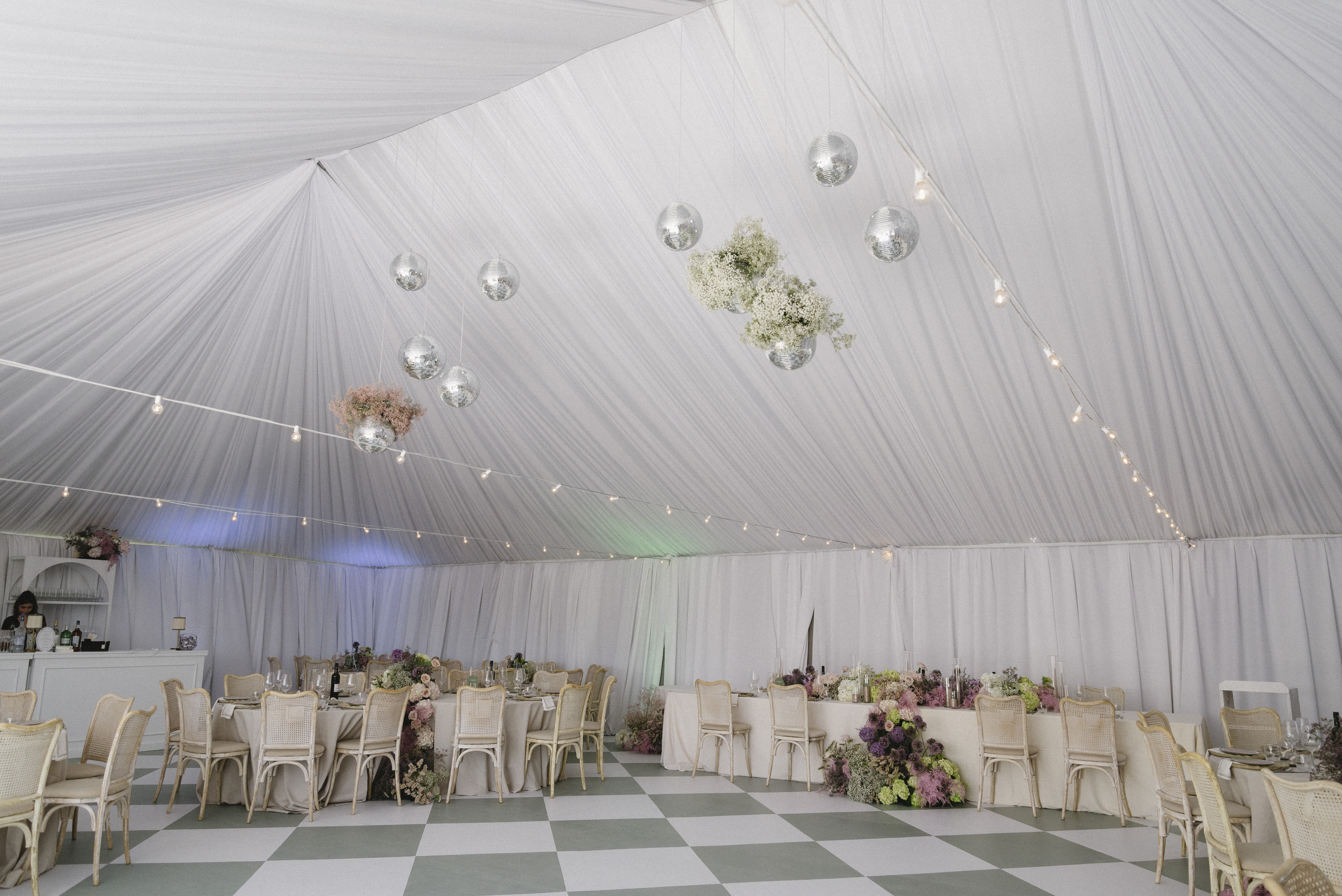 Interior of the Blanc Marquee at Sorella 1881 — draped white canopy, disco balls, and cascading florals over the dance floor