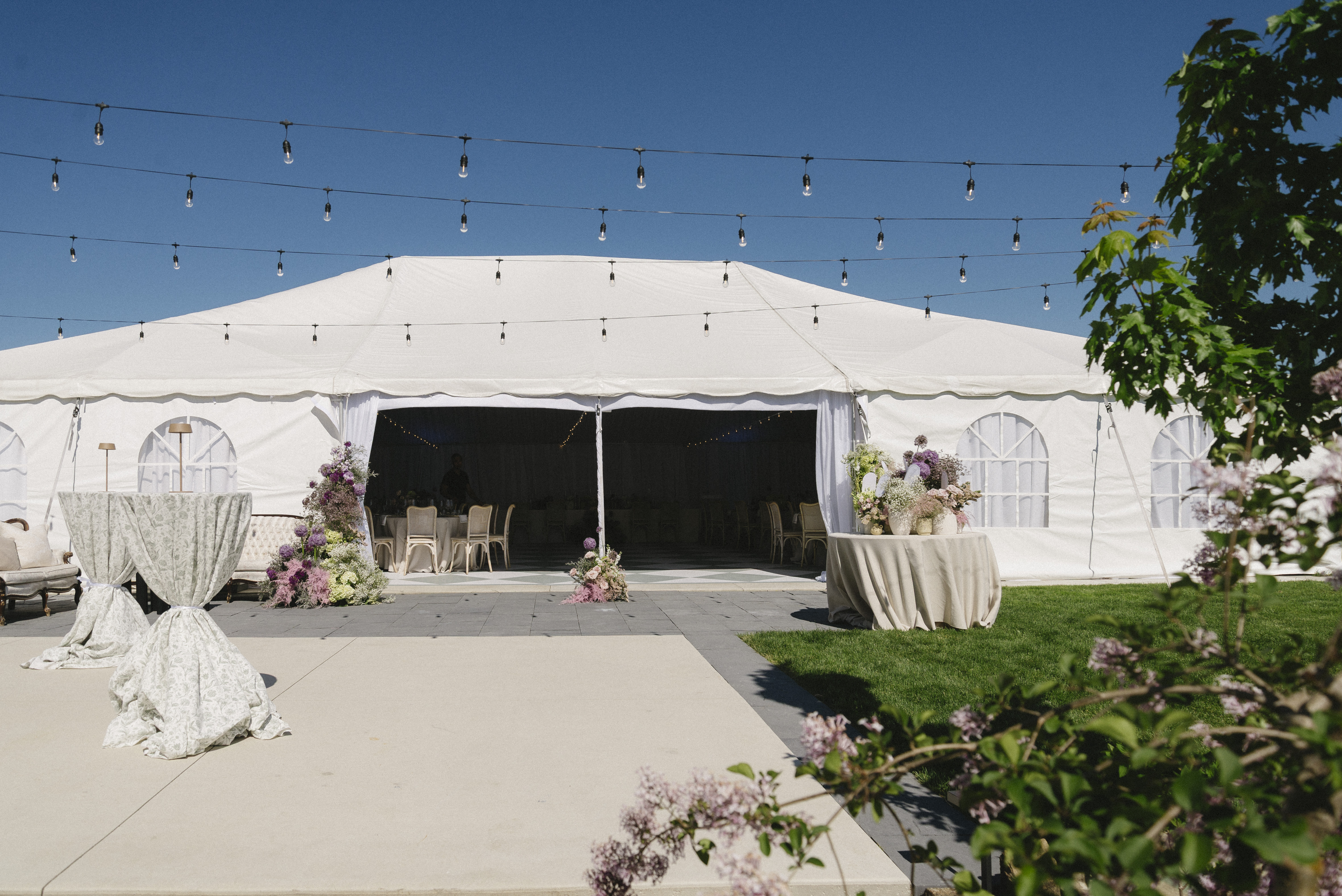Exterior of the Blanc Marquee at Sorella 1881 with open panels and dance floor visible under blue skies