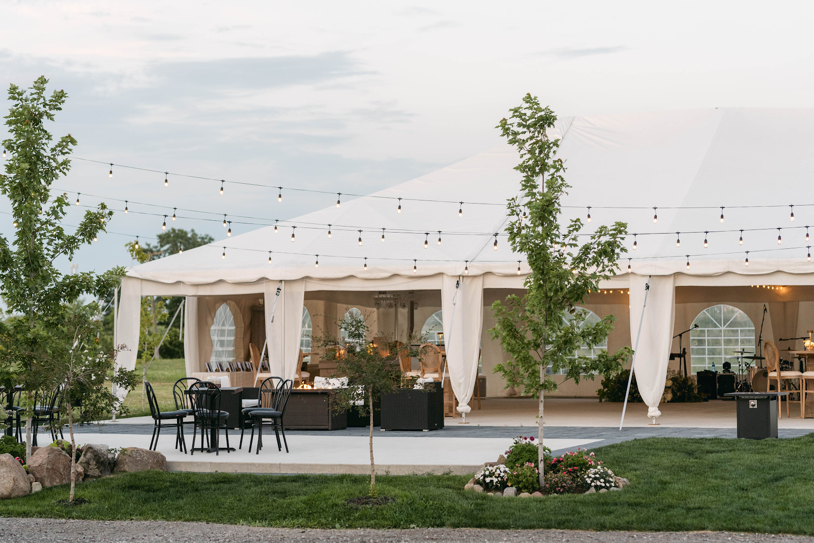 Blanc Marquee at Sorella 1881 — elegant white reception tent with café seating and string lights at dusk