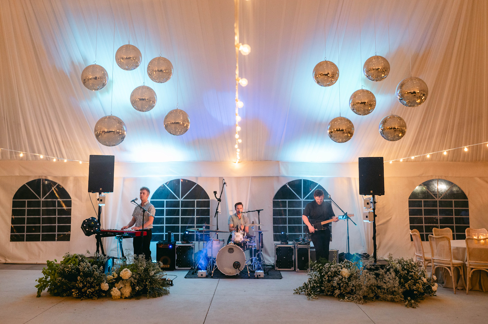 Blanc Marquee reception interior at Sorella 1881 — live band performing under disco balls and string lights